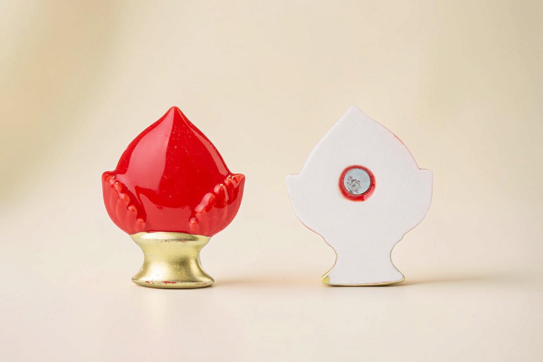 Calamita La Festa Perfetta a forma di pomo in porcellana rossa con base dorata, vista frontale e posteriore