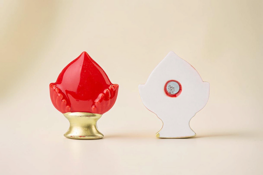 Calamita La Festa Perfetta a forma di pomo in porcellana rossa con base dorata, vista frontale e posteriore