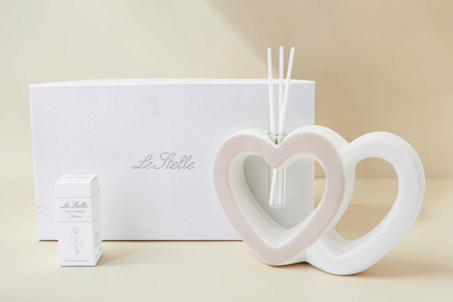 Profumatore La Festa Perfetta a forma di due cuori intrecciati in porcellana bianca e rosa con bastoncini e astuccio