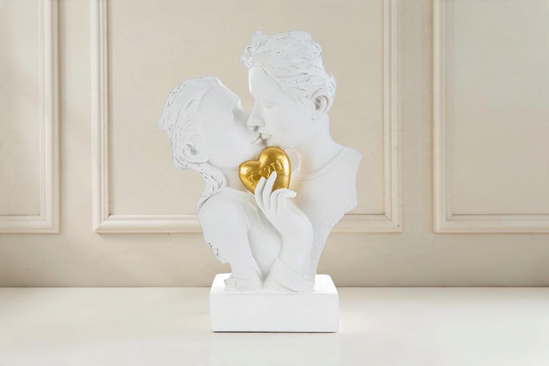 Statua La Festa Perfetta raffigurante una coppia che si bacia in resina bianca con cuore dorato I love you