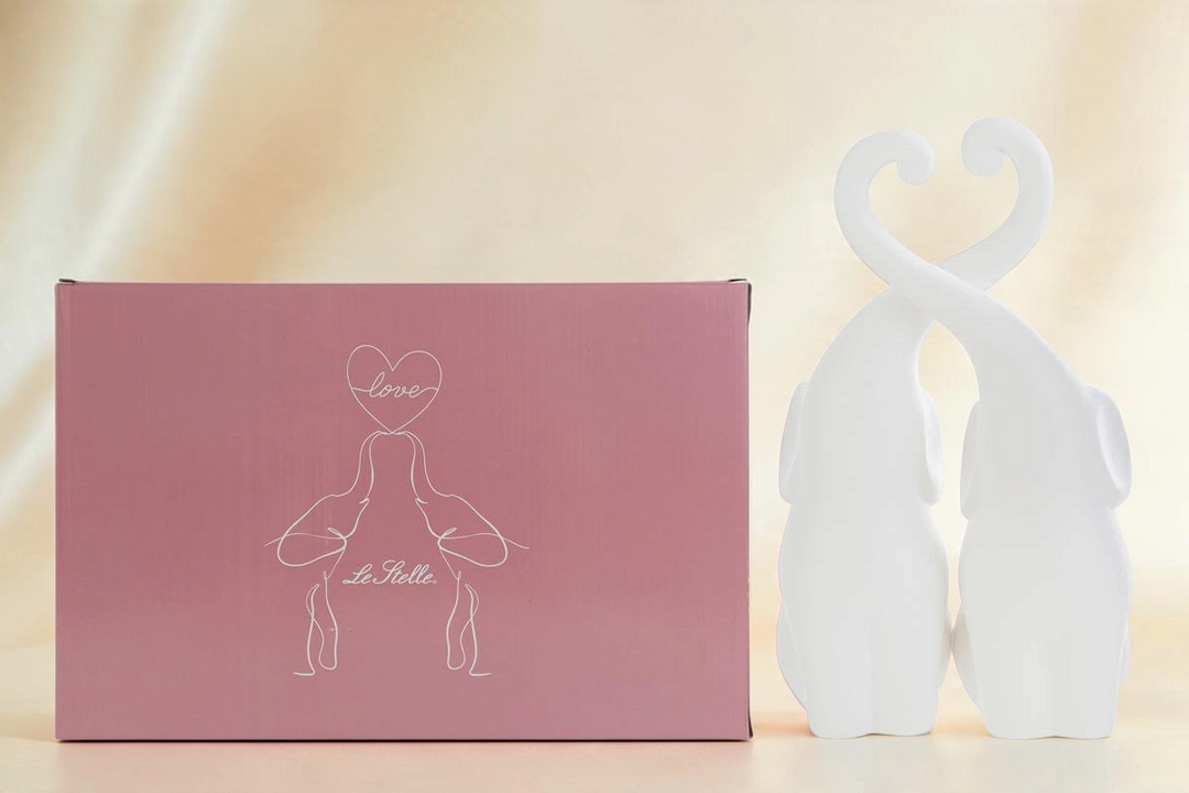 Set di due elefanti in porcellana bianca La Festa Perfetta con proboscidi intrecciate a forma di cuore e scatola rosa