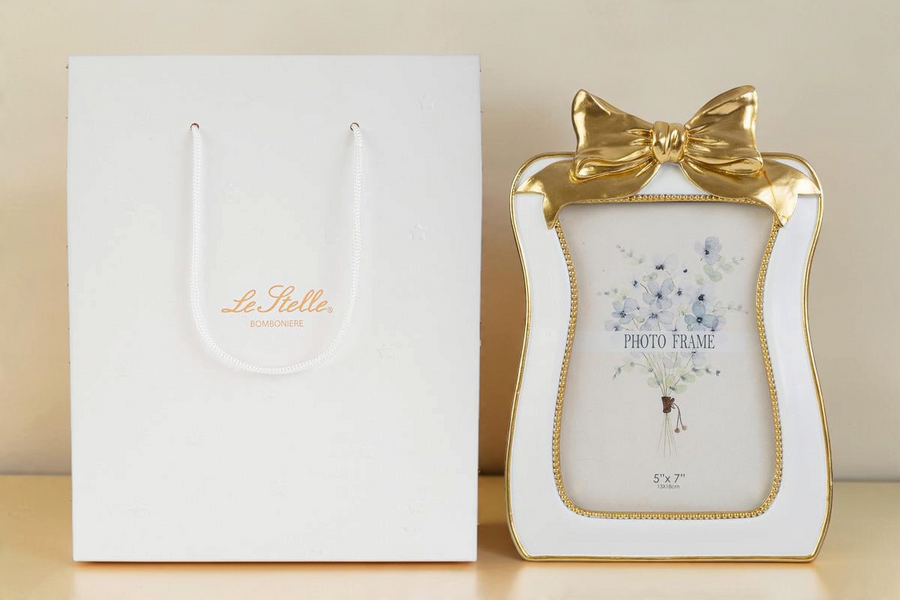 Portafoto La Festa Perfetta in resina bianca e oro con decorazione a fiocco, formato 13x18 cm con shopper inclusa