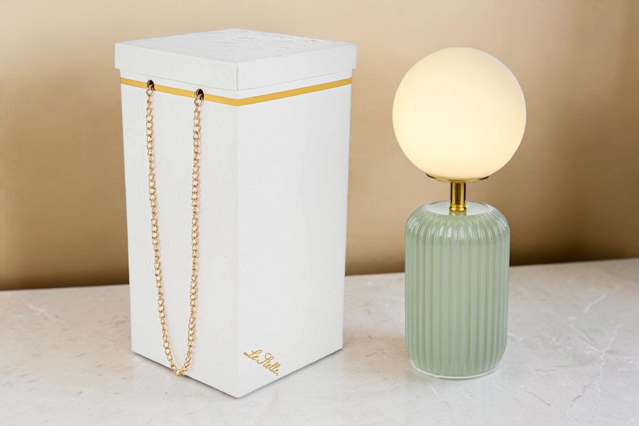 Lampada da tavolo La Festa Perfetta con base in vetro verde scanalato, paralume a sfera bianco e scatola regalo